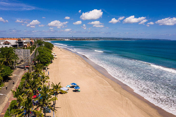 Dramatic aerial view of the famous Kuta beach in Bali, Indonesia, on a sunny day