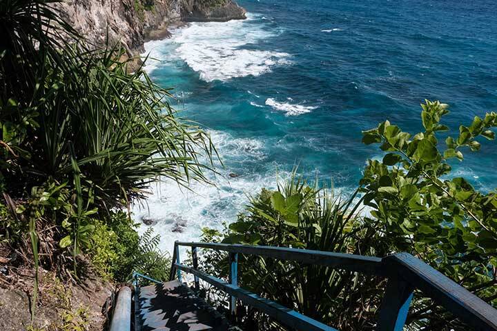 Stairs to Guyangan Waterfall and Pura Segara Kidul & Peguyangan hindu temple on sunny day. Nusa Penida, Indonesia.