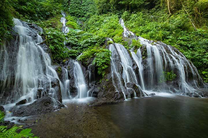 Water flowing through greenery into watering hole at Pucak Manik Waterfall, Bali