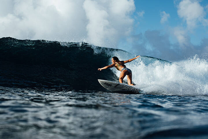 Woman surfing at Cloudbreak