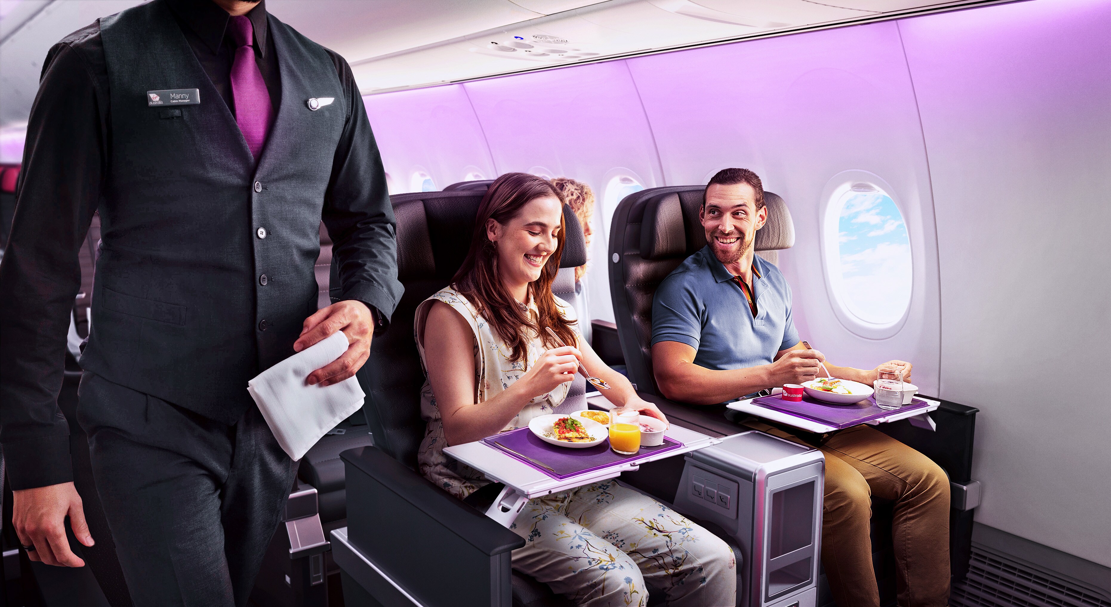 Passengers enjoying their meals during in-flight food service in business class on a Virgin Australia flight.