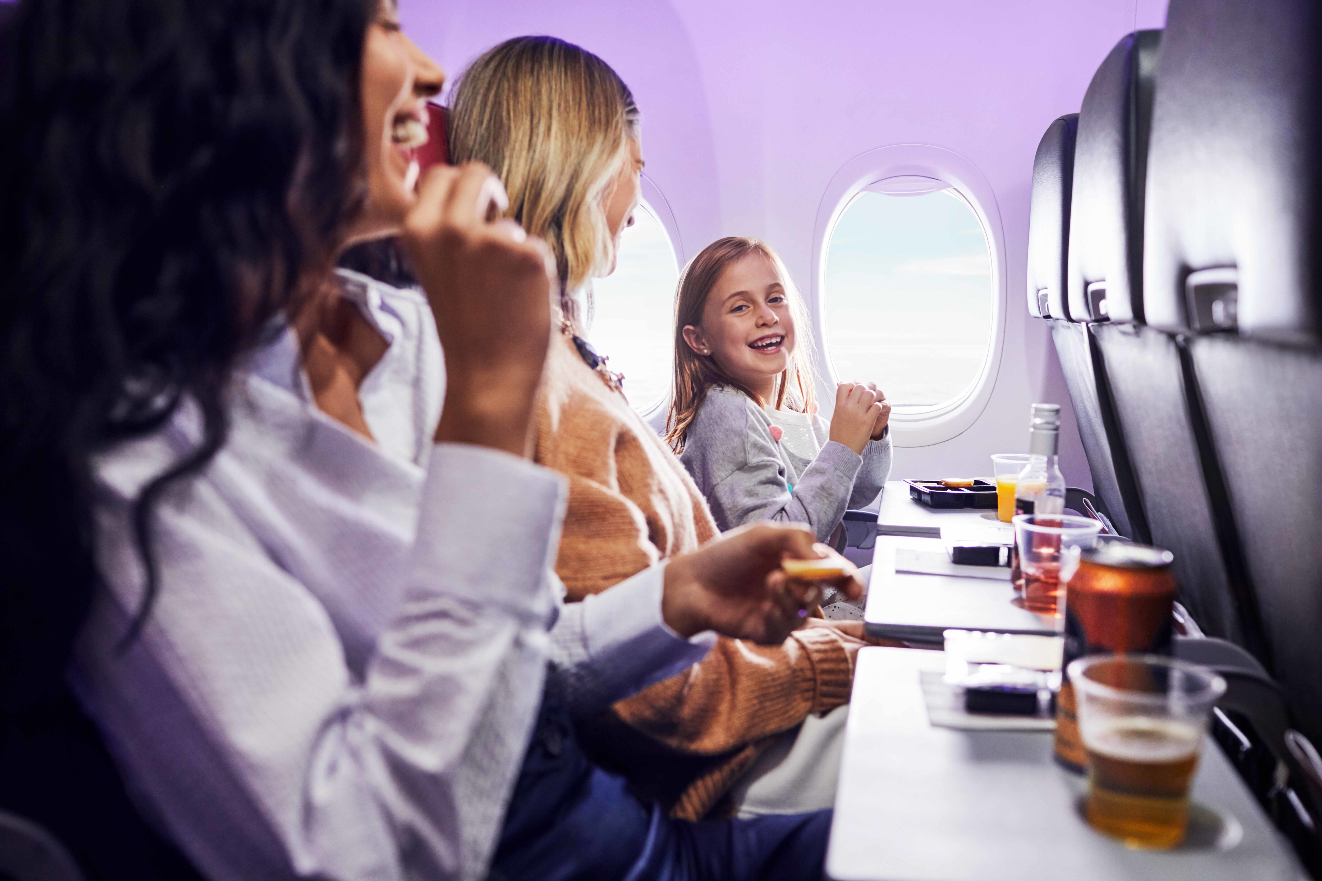 Passengers travelling in Economy X cabin on Virgin Australia flight enjoying food and drinks onboard.