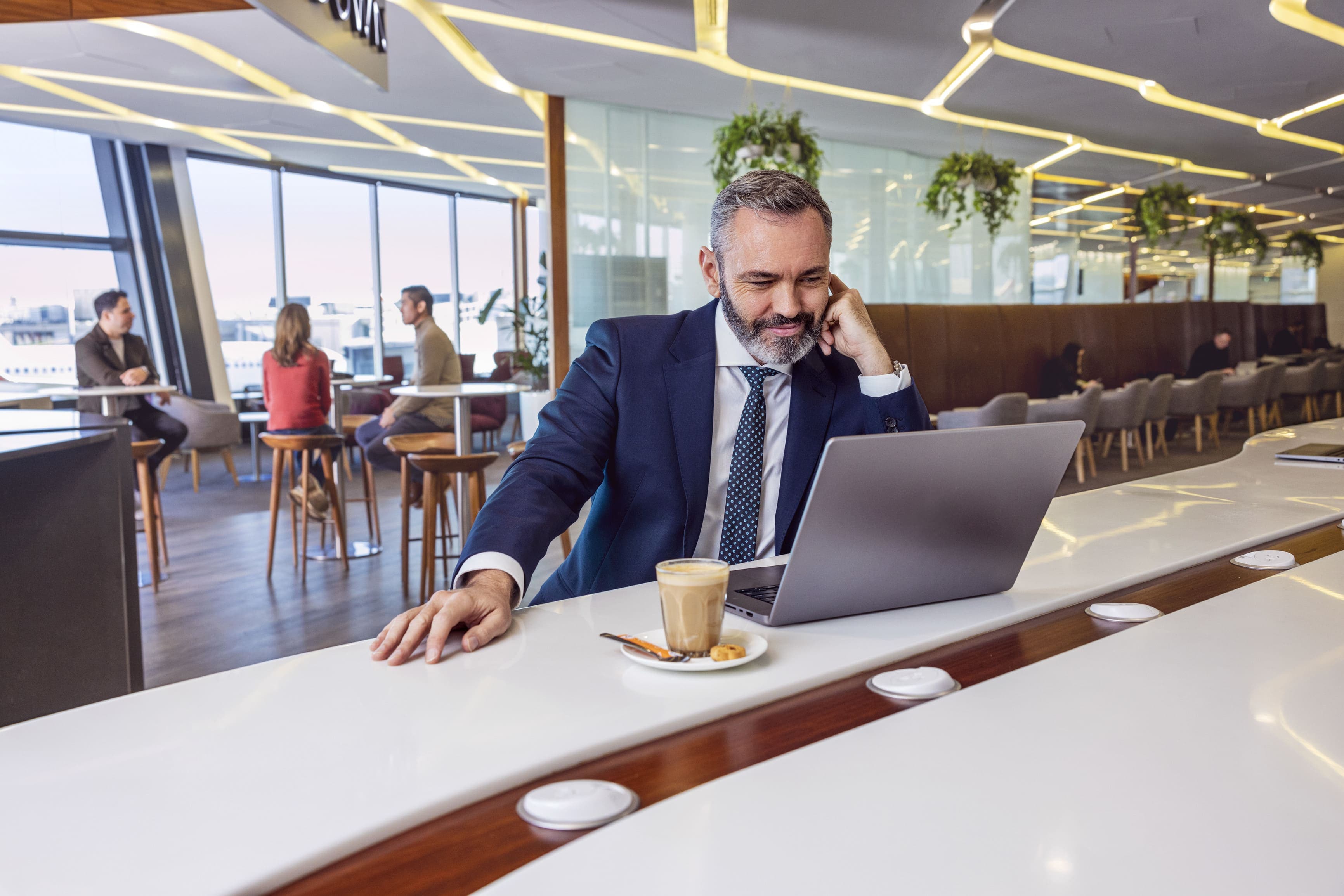 Man sitting in Virgin Australia lounge reading information on website