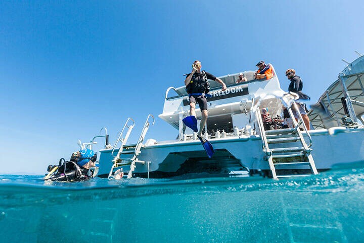 Man jumping from tour group boat on a diving tour on the Great Barrier Reef