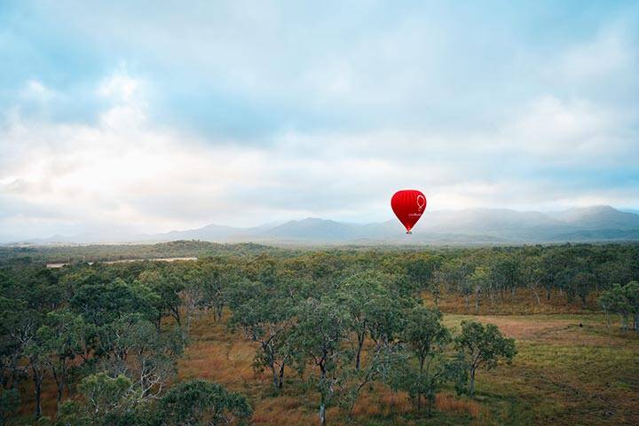 Couple enjoying a hot air balloon at sunrise high above the Atherton Tablelands