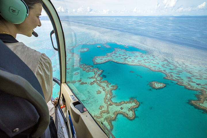 Lady looking out over Heart Reef from a helicopter