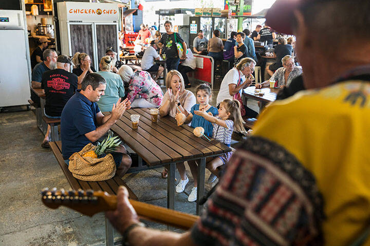 A family relaxing to a performance by Cairns music scene legend Johno Johnson at Rusty's Markets