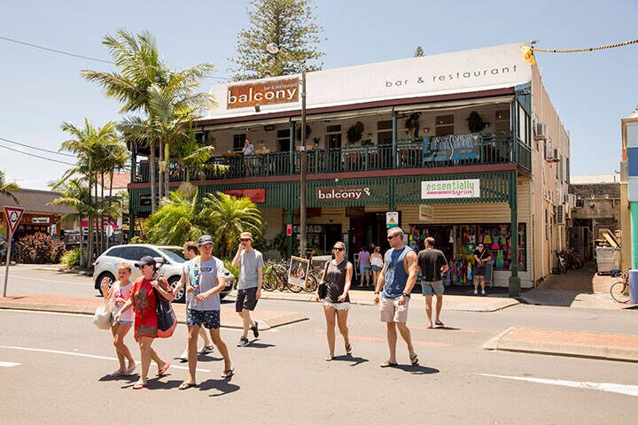 Family crossing the street on a main strip in Byron Bay