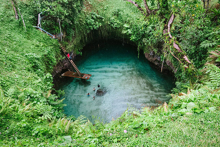 People swimming in To Sua Ocean Trench, Upola Island, Samoa